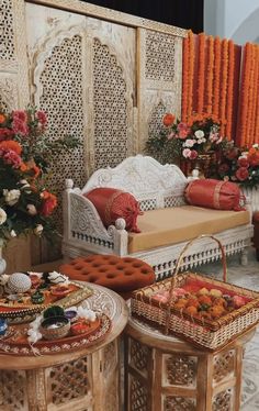 two wooden tables with baskets on them in front of an orange and white wall decorated with flowers