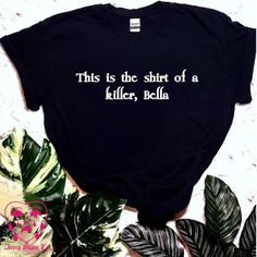 this is the shirt of a killer, bella t - shirt on top of some plants