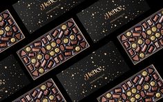 several chocolate bars with gold foil and confetti on them, all lined up in rows