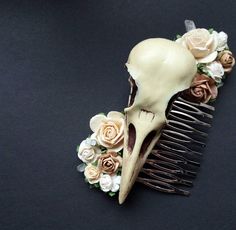 a fake skull with flowers on it sitting next to a comb