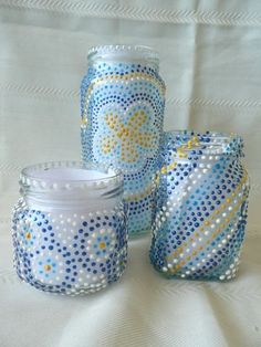 three blue and white glass jars sitting next to each other on top of a table