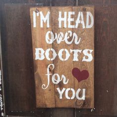 a wooden sign that says i'm head over boots for you