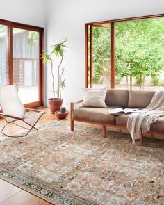 a living room filled with furniture and lots of windows