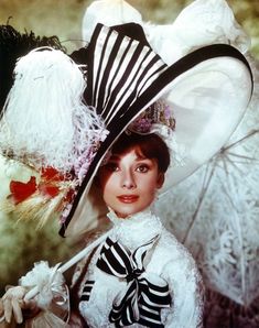 a woman in a white dress and black hat with feathers on it's head