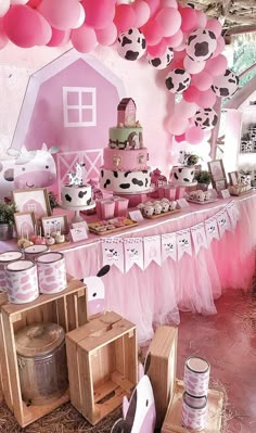 a pink and black cow themed birthday party with balloons, decorations, and desserts