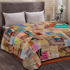 a bed covered in a multi colored patchwork quilt