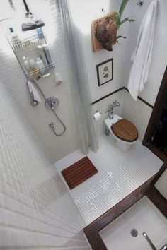 a bathroom with a toilet, sink and shower in it's stall area is seen from above