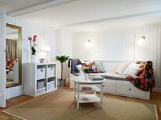 a living room filled with furniture and a white table in front of a large mirror