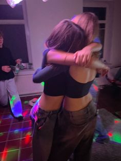 two people dancing in a room with disco lights