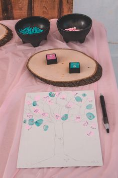 a wooden table topped with two black bowls and a tree cut out on top of it