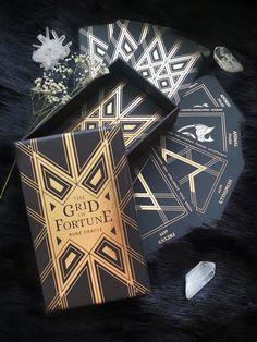 Rune cards in black and gold with a hard box, crystals and white flowers