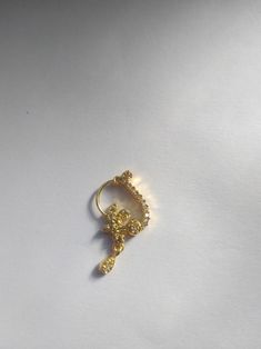 a gold ring that has been placed on top of a white surface with the word love spelled