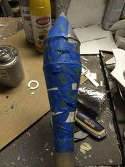 an upside down blue umbrella sitting on top of a table next to some paint cans