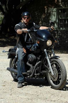 a man riding on the back of a black motorcycle