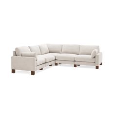 a white sectional couch with wooden legs