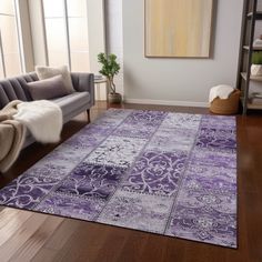 a living room with a purple rug on the floor and a couch in front of it