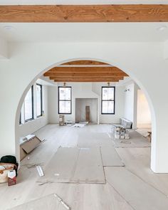 an empty room with white walls and wood beams on the ceiling is under construction in progress