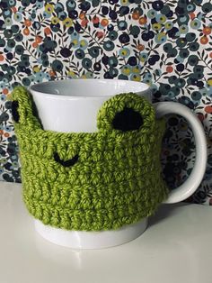 a crocheted coffee cup cozying with eyes