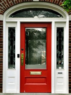 a red front door with two sidelights and a glass pane on the top