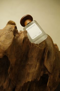 a bottle of water sitting on top of a piece of wood with a wooden lid