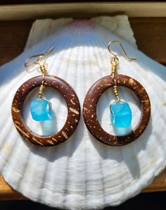 These coconut shell hoop earrings feature a Caribbean blue glass piece made on the island of Java. They are hand wrapped with 14 kt gold filled wire and hang from 14 kt gold filled ear hooks. Coconut shell hoop is 1.5 inches in diameter and the glass piece is approximately 1 cm at widest point.  Due to the natural nature of the coconut shell and handmade nature of the glass, each earring set will vary slightly in size, color, shape, and thickness. Each pair is completely unique. Every purchase r Handmade Small Hoop Jewelry For Vacation, Handmade Small Hoop Earrings For Vacation, Adjustable Small Hoop Jewelry For Beach, Beach Earrings With Recycled Glass And Ear Wire, Turquoise Wire Wrapped Earrings For Beach, Handmade Hoop Jewelry For The Beach, Blue Hoop Jewelry For The Beach, Blue Hoop Earrings With Ear Wire For Beach, Adjustable Small Hoop Jewelry For Vacation