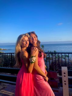 two young women in long dresses hugging each other