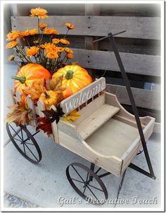 a wooden wagon filled with pumpkins and flowers