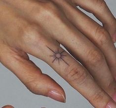 a woman's hand with a small star tattoo on it