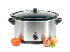 an image of a slow cooker with onions and carrots next to it on a white background