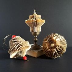 an open book is sitting on top of a table next to two folded books and a candle