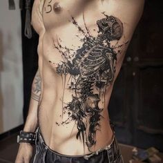 a man with a skeleton tattoo on his stomach and chest is posing for the camera