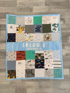 a patchwork quilt on the floor with words and pictures printed on it that says,'freedie 5th december 2012 '