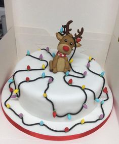 a christmas cake decorated with lights and a reindeer figure