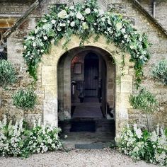 an old building with flowers and greenery on it