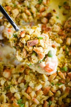 a spoon full of food that is being lifted from the casserole dish with meat and veggies