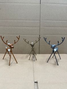 three metal reindeer figurines standing next to each other on top of a table