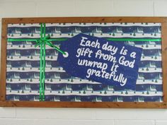 a blue sign with a green bow on it that says each day is a gift from godwrap it gratefully