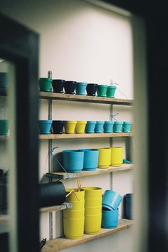 the shelves are filled with many different colored pots