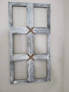 an old window with chicken wire in the middle is hung on a wall above a toilet