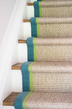 the carpeted stairs are lined with blue and green rugs