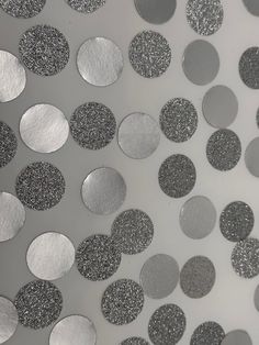 silver and black circles are arranged on a white surface, with one circle in the middle