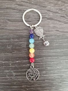 a keychain with a tree of life charm hanging from it's side