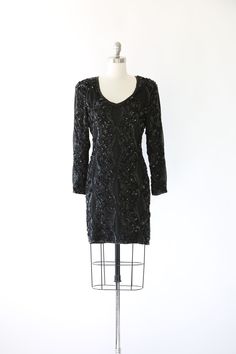 "Stunning Vintage 1980s black heavily beaded + sequin Silk mini dress Deco motif Deep V bodice long sleeve ultra sliming fit 100% silk Great Vintage condition M e a s u r e m e n t s: Size: Vintage Size 4 - fit like a S M BUST: 18\" Waist: 15\" Hips: 18 1/2\" Total Length: 36\" Label: Nite Line Fabric: 100% Silk Sleeves: 23 1/2\" +All Measurements are taking while garment is lying flat + + Jewelry, belts, and any other accessories are NOT included unless specifically stated in description + i n Flat Jewelry, 1980s Dresses, Gauze Dress, Mexican Dresses, Batik Dress, Silk Mini Dress, Sequin Beading, Sequin Mini, Sequin Mini Dress