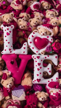 the word love spelled with teddy bears surrounded by pink roses and hearts on a bed of other stuffed animals