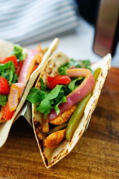 two tacos are sitting on a wooden table