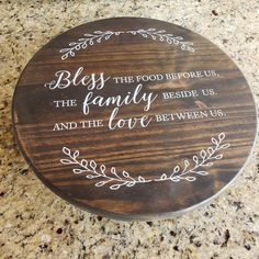 a wooden plaque that says,'be the food before us, the family beside us and the love between us '