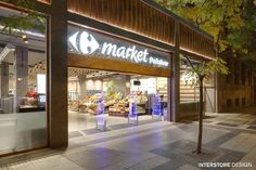 the front entrance to a market store lit up at night