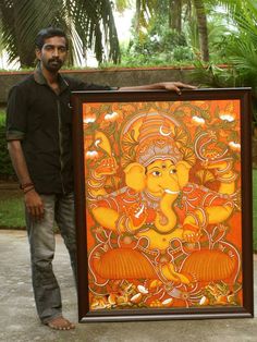 a man standing next to an orange and yellow painting on a wall with trees in the background