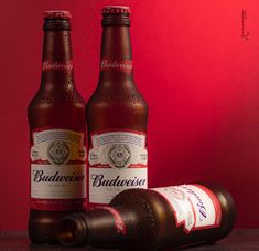 two bottles of budweiser beer sitting next to each other