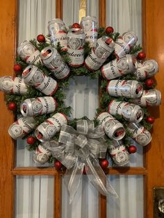 a wreath made out of beer cans is hung on the front door with christmas decorations